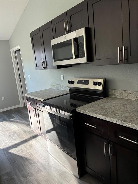 13033 Southwest 82nd Ave Road Ocala, FL 34473 - Photo 13 of 27 a kitchen with stainless steel appliances granite countertop a stove microwave and sink