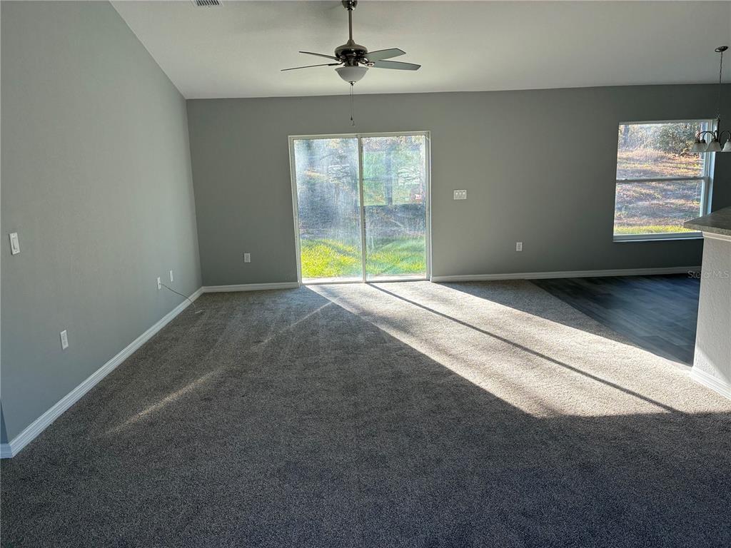 13033 Southwest 82nd Ave Road Ocala, FL 34473 - Photo 8 of 27 an empty room with windows and ceiling fan
