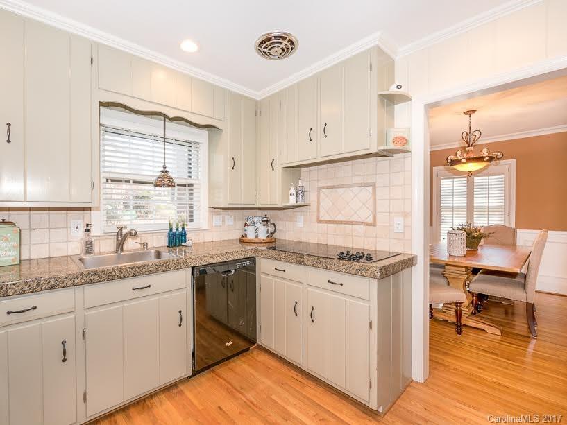 5600 Robinhood Road Charlotte, NC 28211 - Photo 2 of 22 a kitchen with a stove a sink and white cabinets with wooden floor