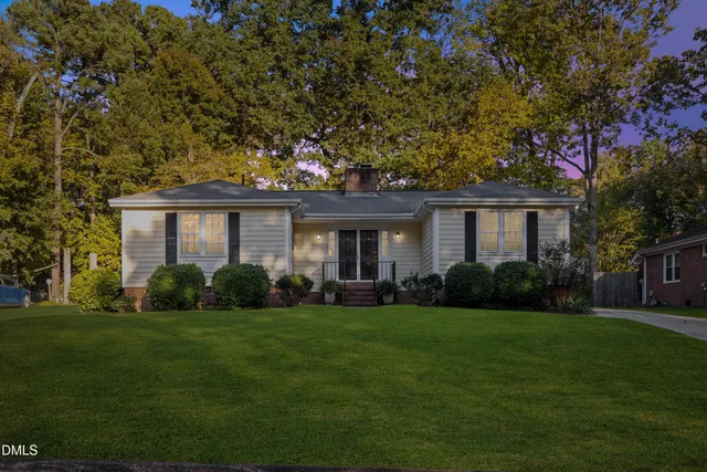 a front view of a house with a garden and yard