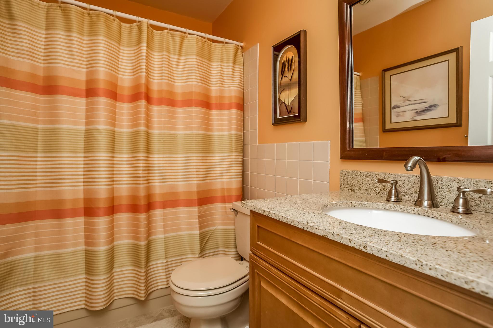 9407 Oak White Road Baltimore, MD 21236 - Photo 24 of 30 a bathroom with a granite countertop toilet sink and mirror