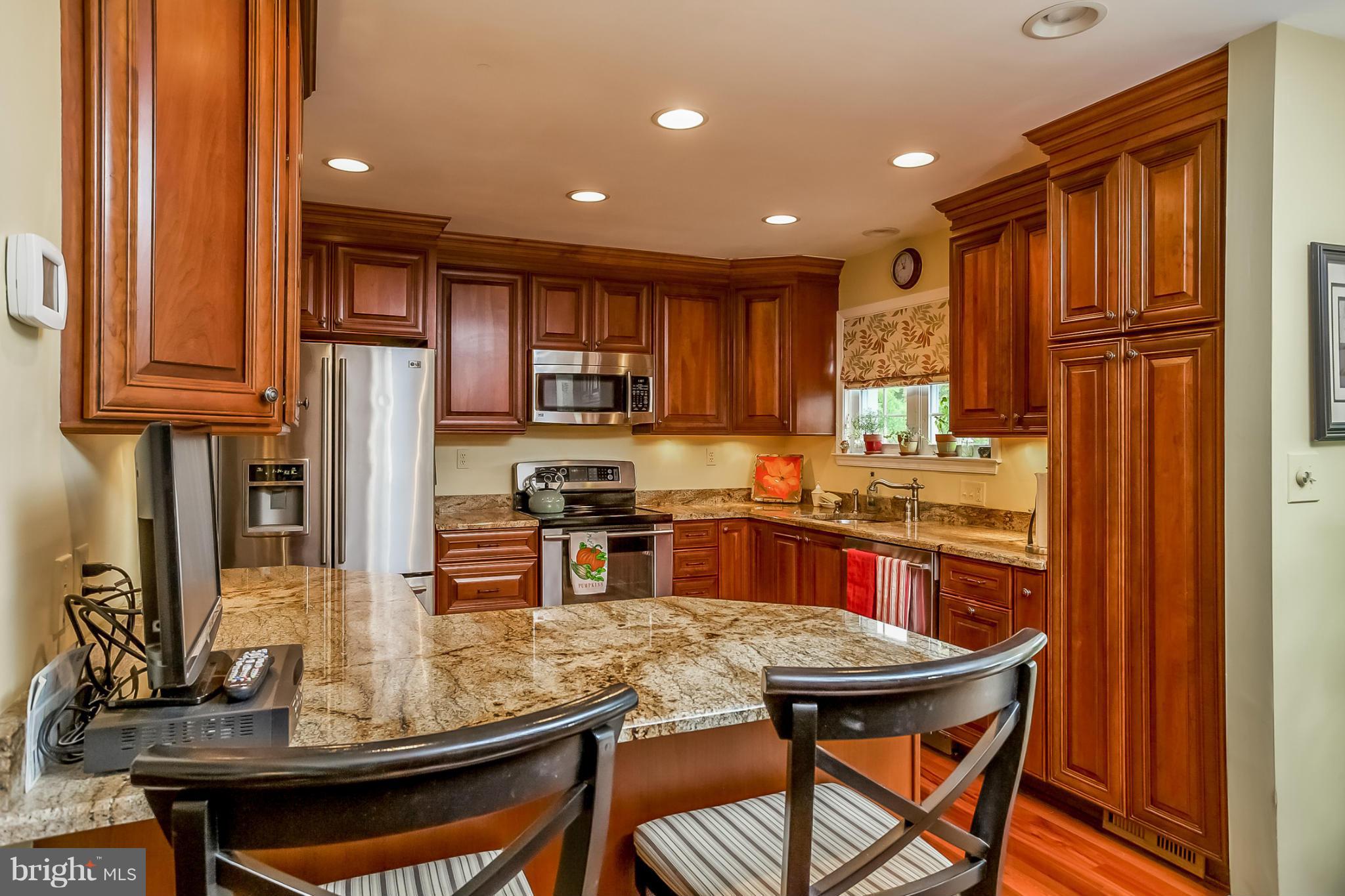 9407 Oak White Road Baltimore, MD 21236 - Photo 8 of 30 a kitchen with stainless steel appliances granite countertop a stove a refrigerator a sink a dining table and chairs with wooden floor