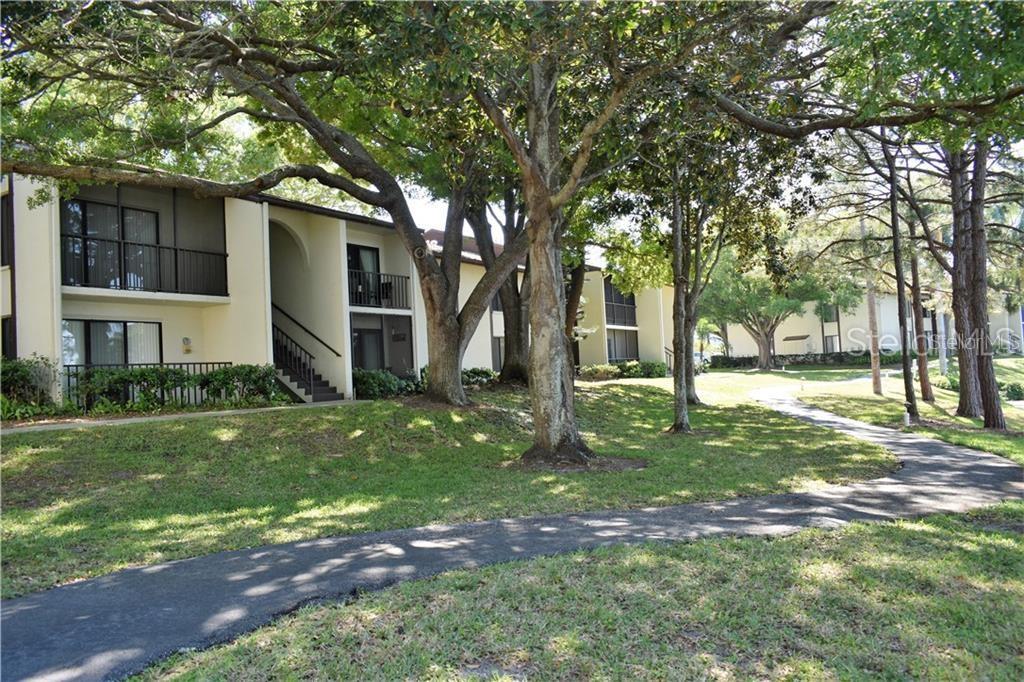 2575 Pine Ridge Way South, Unit G2 Palm Harbor, FL 34684 - Photo 1 of 1 a view of a house with backyard and a tree