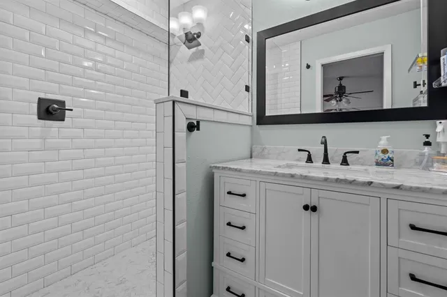 a bathroom with a granite countertop sink vanity and mirror