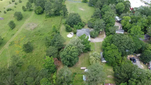 an aerial view of residential house with outdoor space and trees all around