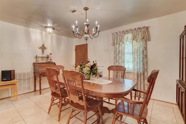 a view of a dining room with furniture and chandelier