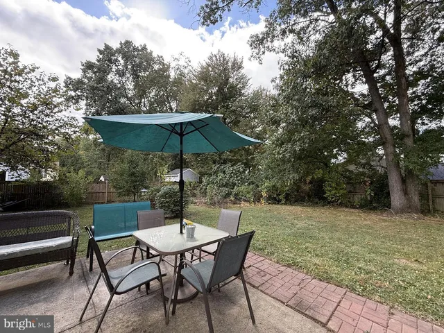 a view of backyard with seating and trees