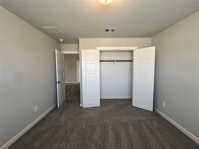 an empty room with closet and a window