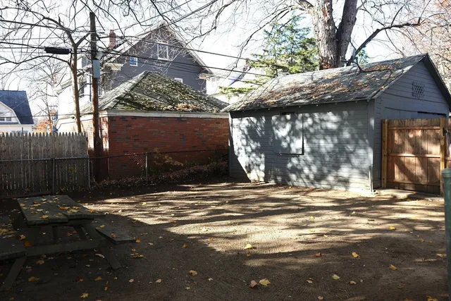 a backyard of a house with fountain table and chairs