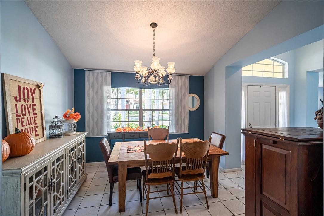1315 Sabal Lakes Road Delray Beach, FL 33445 - Photo 10 of 38 a view of a dining room with furniture and chandelier