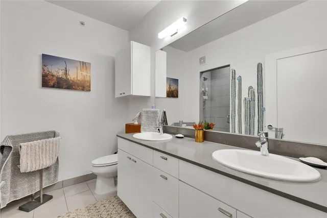 a bathroom with a double vanity sink mirror and toilet
