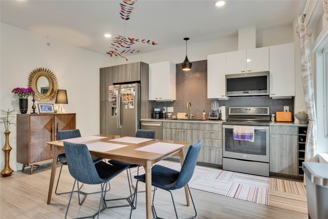 4361 South Congress Avenue, Unit 335 Austin, TX 78745 - Photo 3 of 22 a kitchen with a table chairs microwave and cabinets