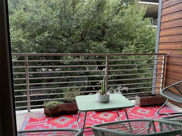 a view of a balcony with two chairs and a potted plant