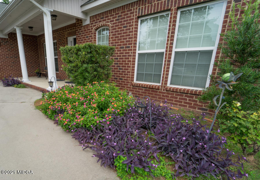126 Timber Ridge Boulevard Byron, GA 31008 - Photo 24 of 26 a house with a lot of flower plants in front of door