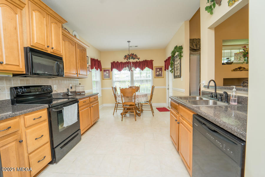 126 Timber Ridge Boulevard Byron, GA 31008 - Photo 5 of 26 a kitchen with stainless steel appliances granite countertop a stove top oven a sink dishwasher and white cabinets with wooden floor