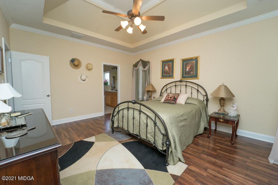 126 Timber Ridge Boulevard Byron, GA 31008 - Photo 10 of 26 a bedroom with a bed and a dresser with wooden floor