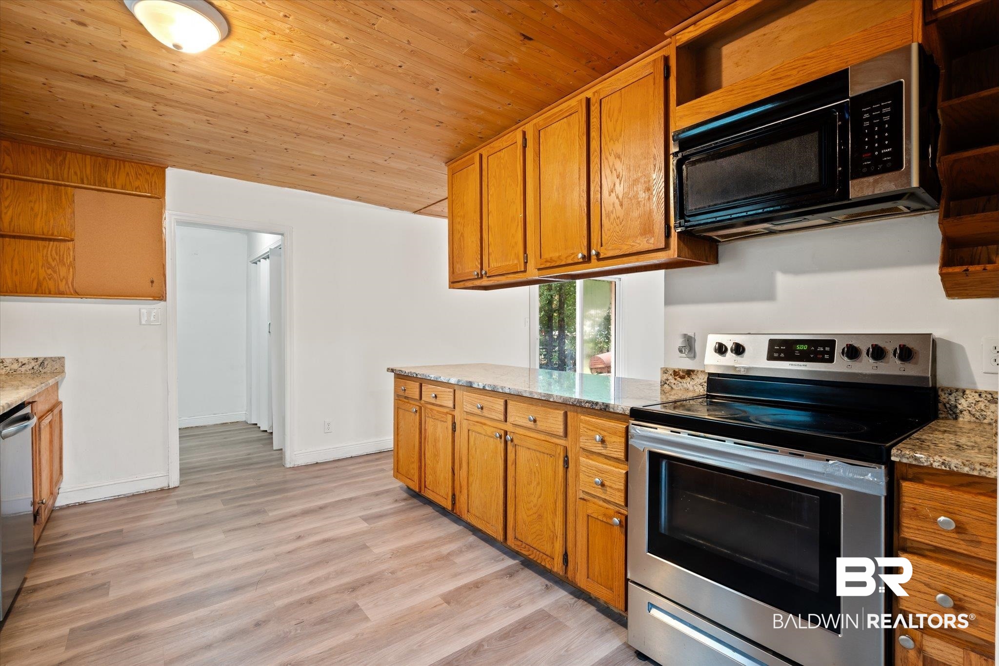 9445 Howells Ferry Road Semmes, AL 36575 - Photo 8 of 20 Kitchen featuring light stone countertops, stainless steel appliances, wood ceiling, and light hardwood / wood-style flooring