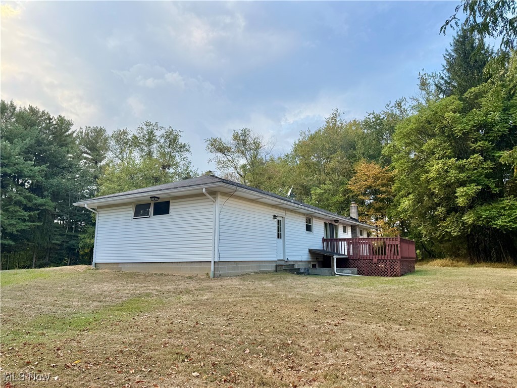 4878 Wylie Ridge Road New Cumberland, WV 26047 - Photo 16 of 20 Back of house with a wooden deck, a lawn, and view of scattered trees