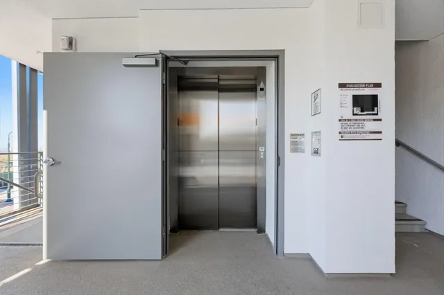 a view of a refrigerator in kitchen and an empty room