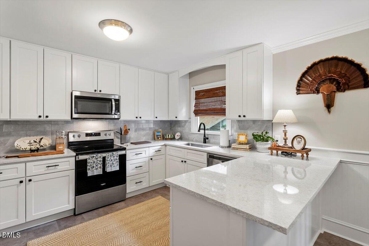 8604 Lobelia Street Raleigh, NC 27603 - Photo 13 of 27 a kitchen with a sink a stove and cabinets