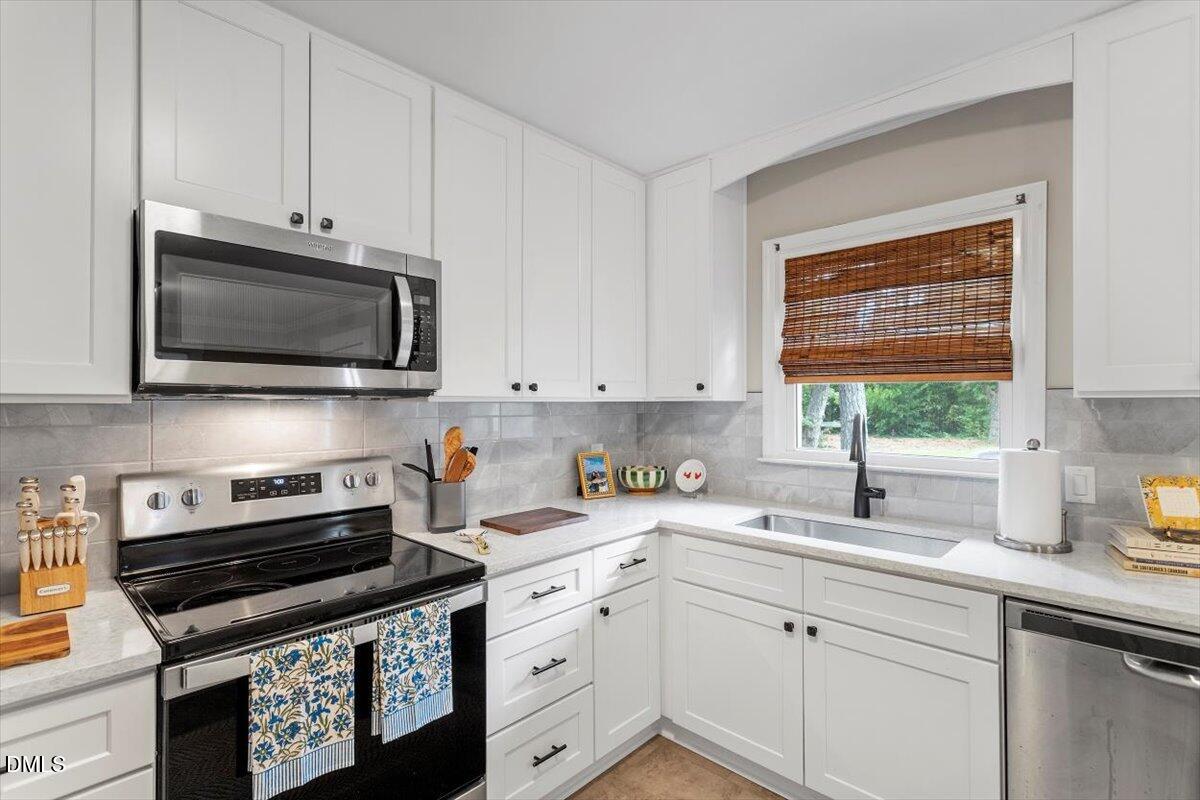 8604 Lobelia Street Raleigh, NC 27603 - Photo 14 of 27 a kitchen with stainless steel appliances a stove a sink and a microwave