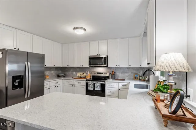 a kitchen with stainless steel appliances granite countertop a refrigerator sink and stove