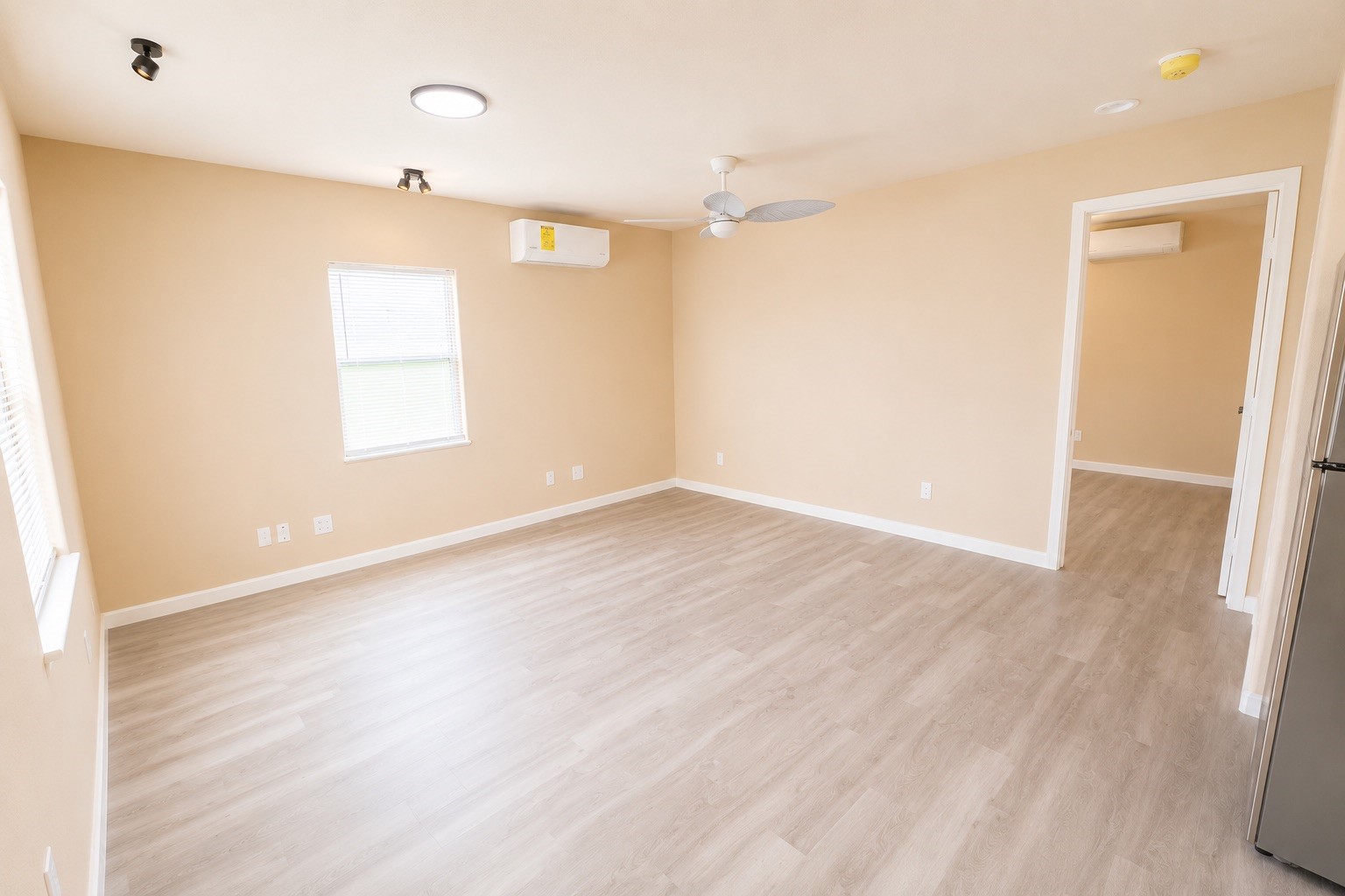 1021 North Sage Road Crystal Beach, TX 77650 - Photo 16 of 22 Spacious room with light wood flooring, neutral walls, and ample natural light, featuring modern ceiling fans and energy-efficient lighting.