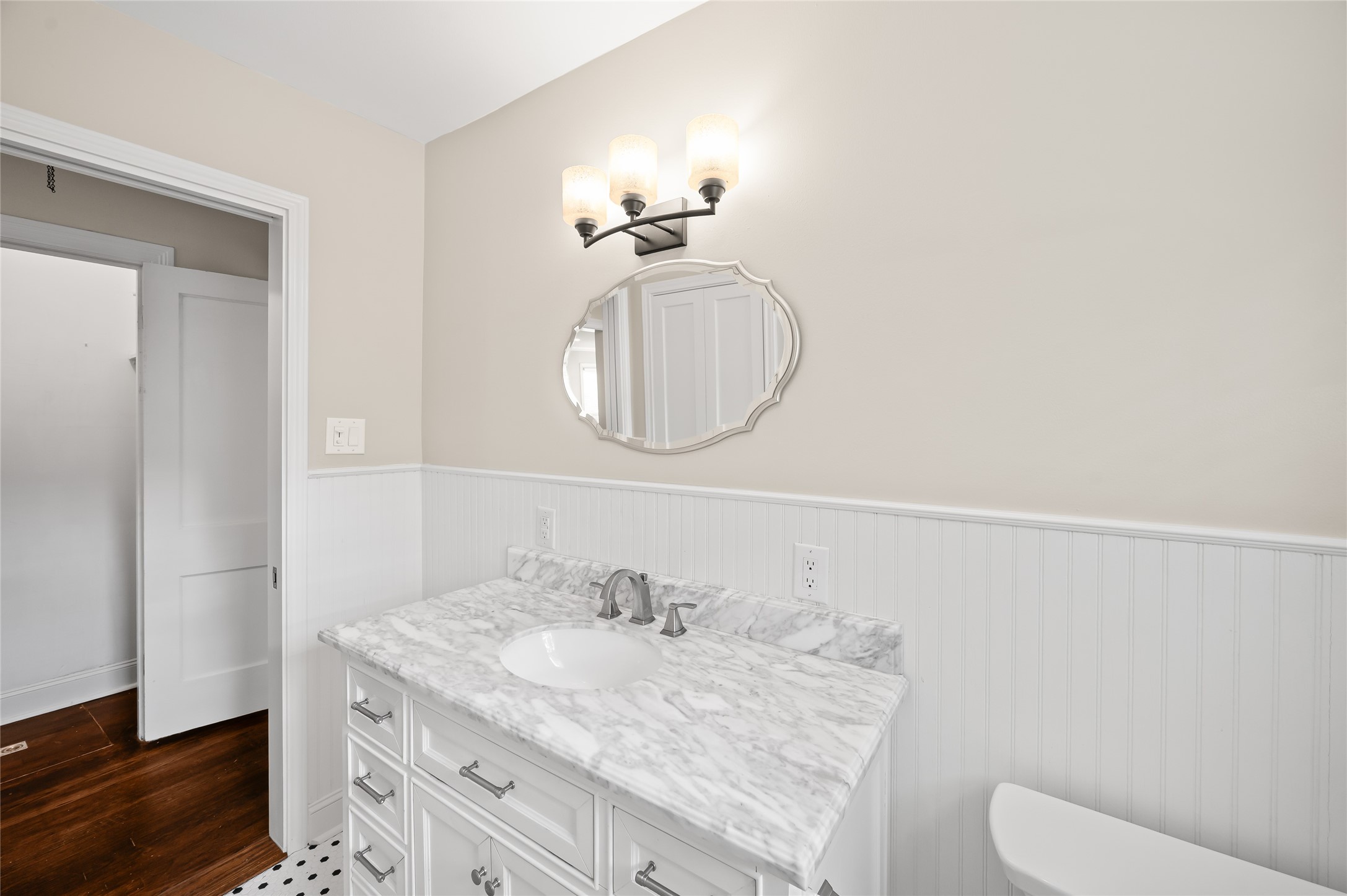 6673 Sylvan Road Houston, TX 77023 - Photo 17 of 39 a bathroom with a granite countertop sink a toilet and a mirror