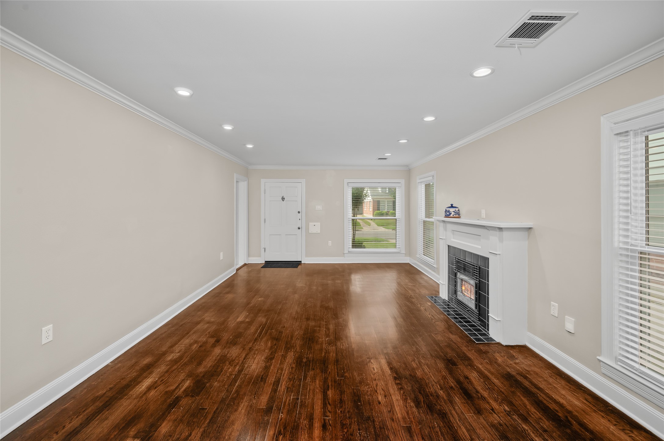 6673 Sylvan Road Houston, TX 77023 - Photo 6 of 39 a view of empty room with wooden floor and fireplace