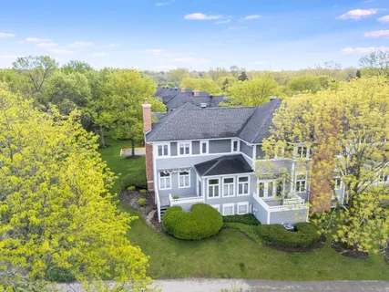 a view of a big house with a big yard and large trees
