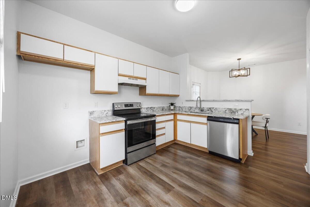 3831 Pin Oak Road Raleigh, NC 27604 - Photo 7 of 24 a kitchen with granite countertop white cabinets and white appliances