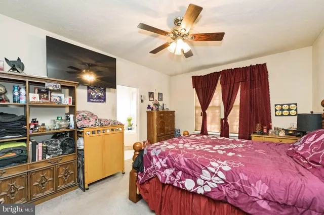 a bedroom with a bed a large window and book shelf