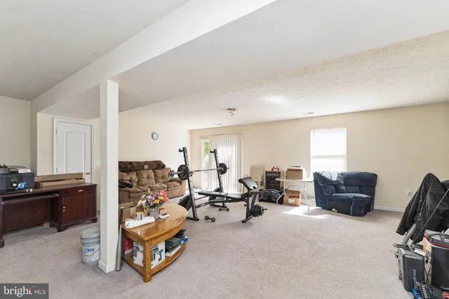 a living room with furniture gym equipment and a window