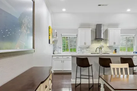a kitchen with a table chairs sink and cabinets