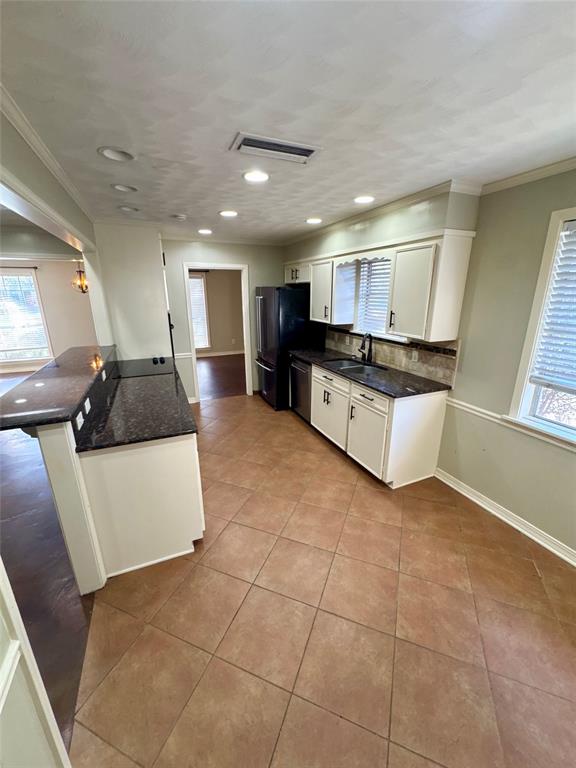 710 Robards Street Shreveport, LA 71105 - Photo 3 of 12 a large white kitchen with kitchen island a sink a stove a counter space and cabinets
