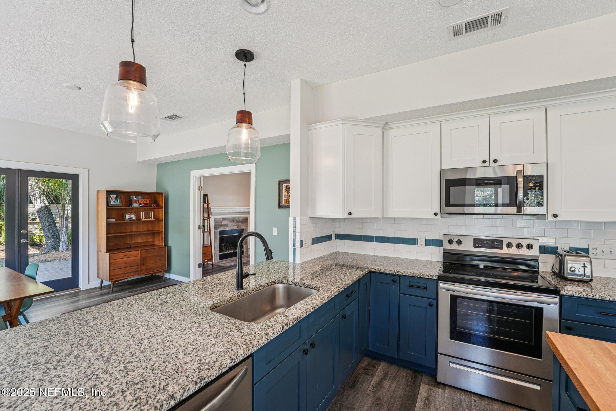 502 Royal Road St. Augustine, FL 32086 - Photo 11 of 34 a kitchen with stainless steel appliances granite countertop a sink and stove top oven