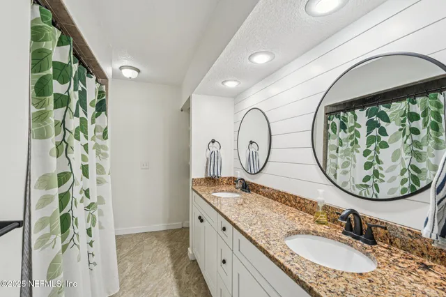 a bathroom with a granite countertop sink and mirror