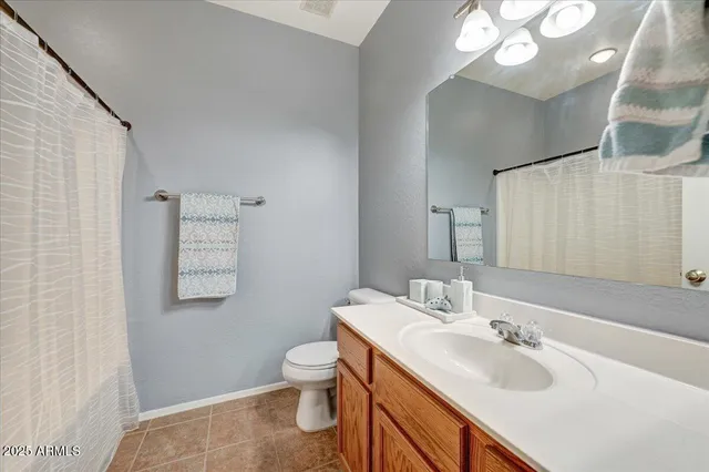 a bathroom with a sink vanity mirror and toilet
