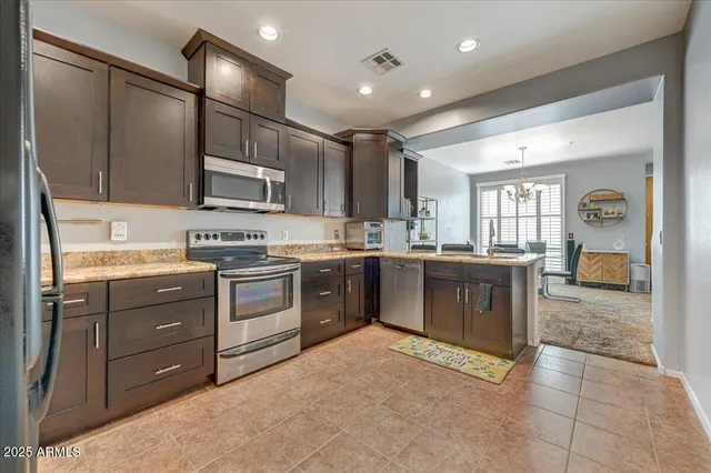 a kitchen with stainless steel appliances granite countertop a stove sink and cabinets
