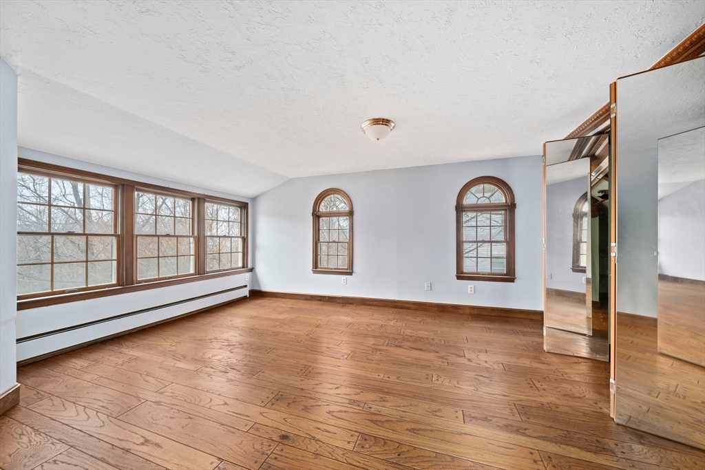79 Pecksuot Road Weymouth, MA 02191 - Photo 17 of 42 a view of an empty room with glass door and wooden floor