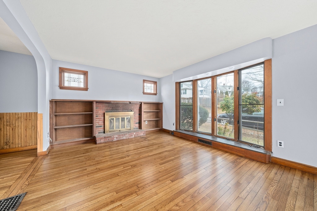 79 Pecksuot Road Weymouth, MA 02191 - Photo 6 of 42 a view of an empty room with a window and wooden floor
