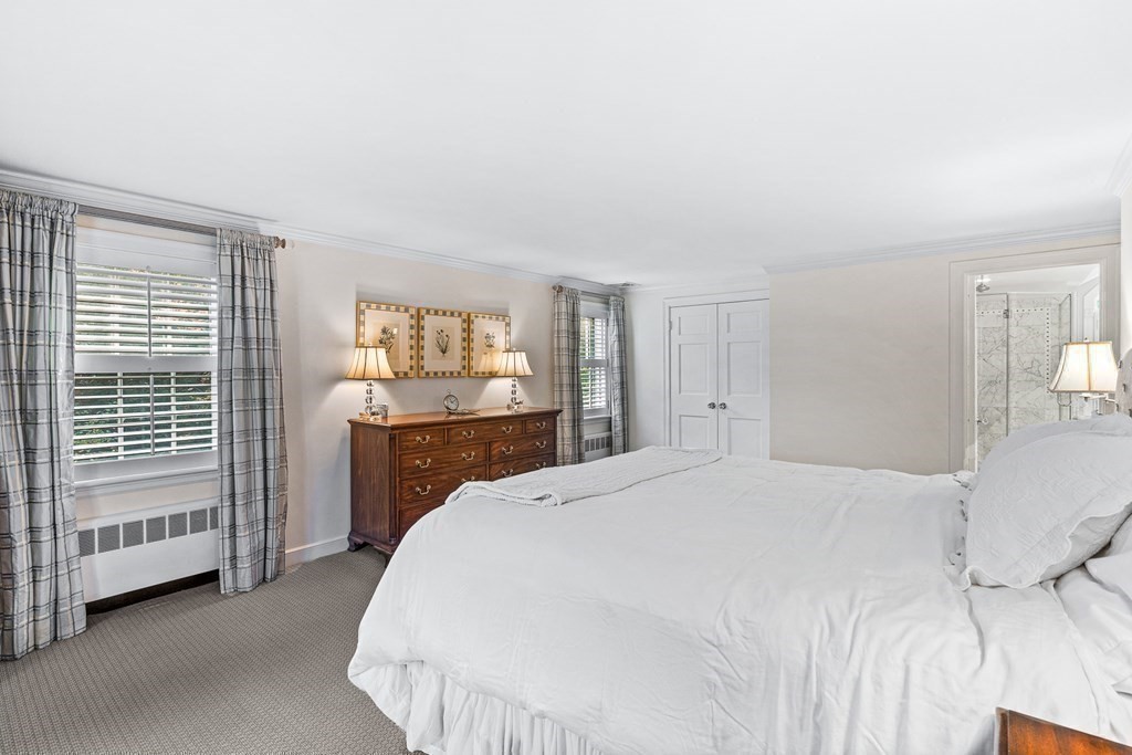 138 Hampshire Road Wellesley, MA 02481 - Photo 14 of 25 a spacious bedroom with a bed a mirror and a window