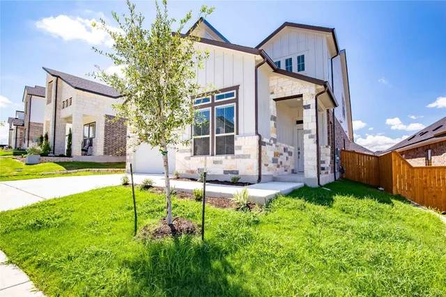 a view of a house with a big yard and large windows
