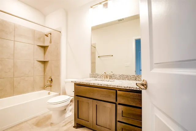 a bathroom with a granite countertop sink toilet and shower