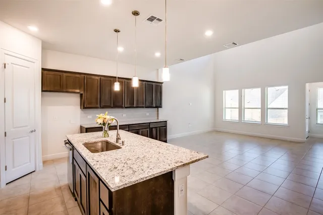 a kitchen with stainless steel appliances granite countertop a sink a oven a counter space and cabinets