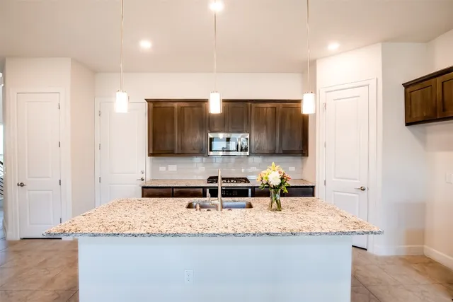 a kitchen with granite countertop a sink and a refrigerator
