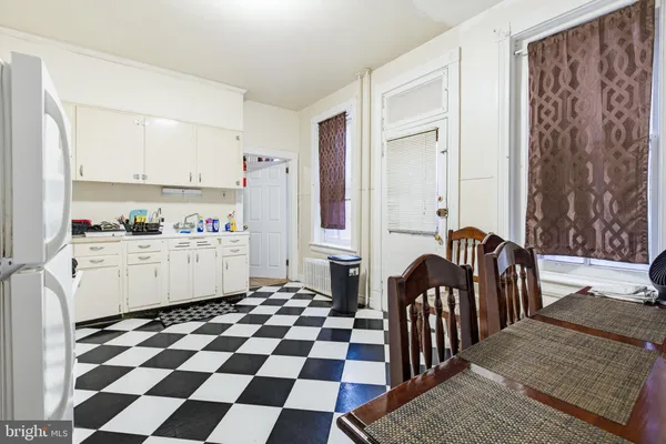 a kitchen with a checkered floor and white cabinets