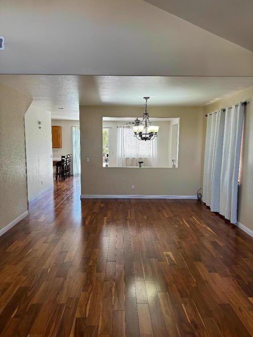 949 Terraza Street Soledad, CA 93960 - Photo 5 of 38 an empty room with wooden floor and chandelier