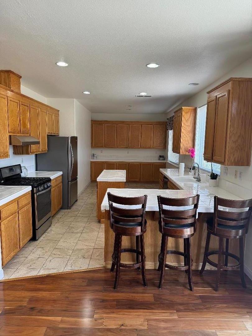 949 Terraza Street Soledad, CA 93960 - Photo 9 of 38 a kitchen with a table chairs sink and cabinets