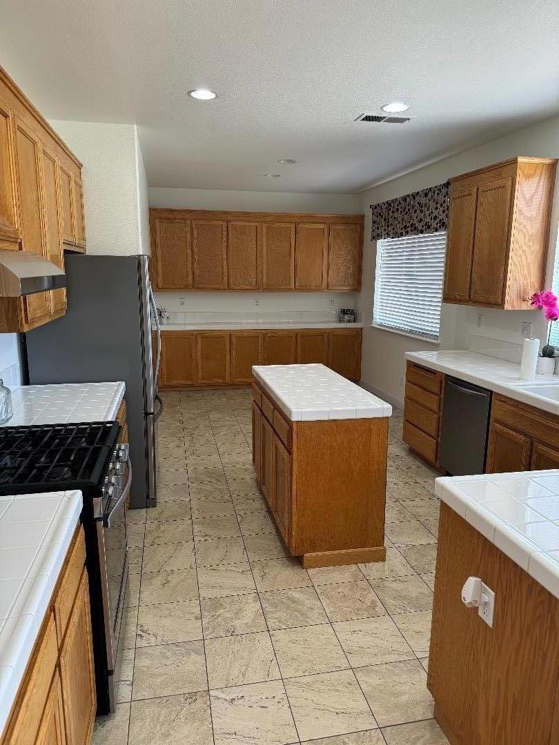 949 Terraza Street Soledad, CA 93960 - Photo 10 of 38 a kitchen with stainless steel appliances a stove a sink a counter top space and cabinets